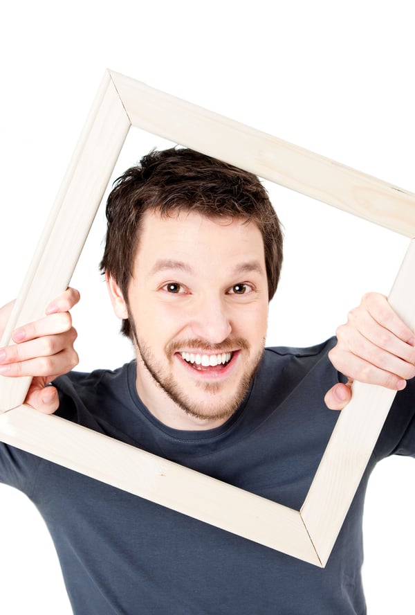 Man looking through picture frame
